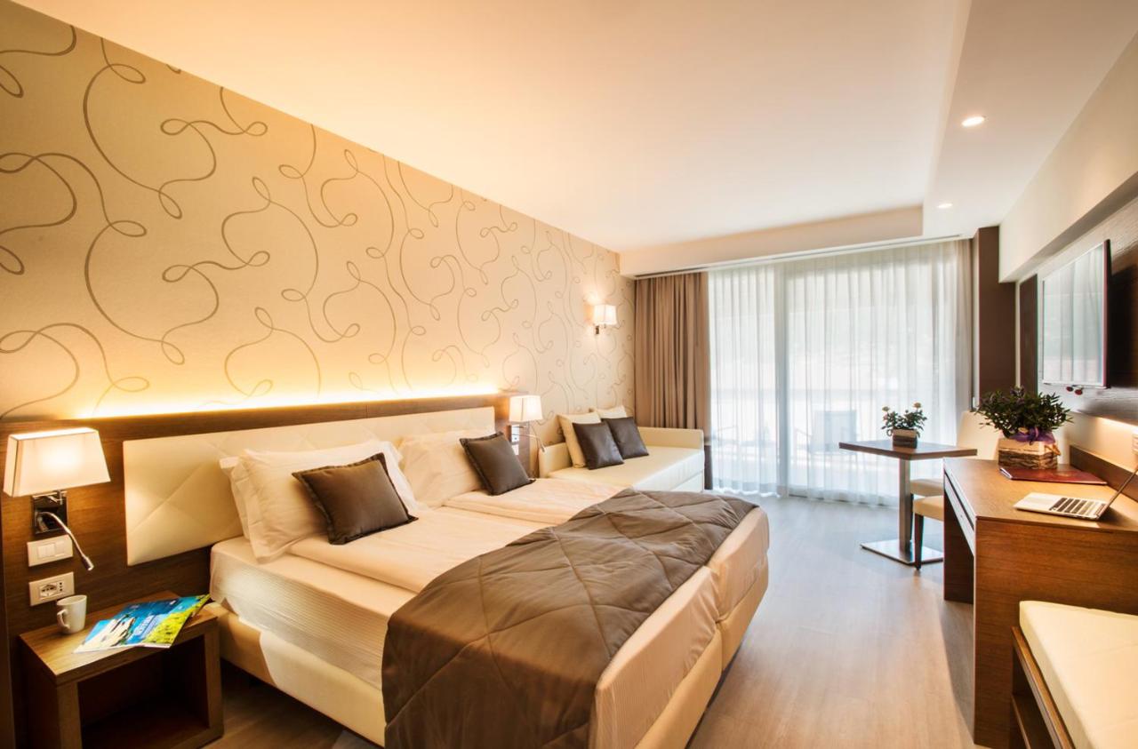 een hotelkamer met een groot bed en een bureau bij Hotel Bisesti ***S in Garda