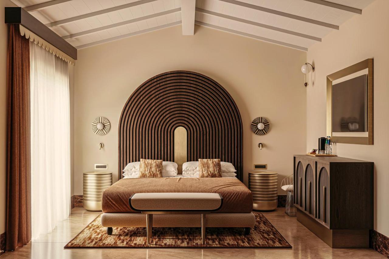 een slaapkamer met een groot bed en een grote boog bij Spiagge San Pietro, a charming & relaxing resort in Castiadas