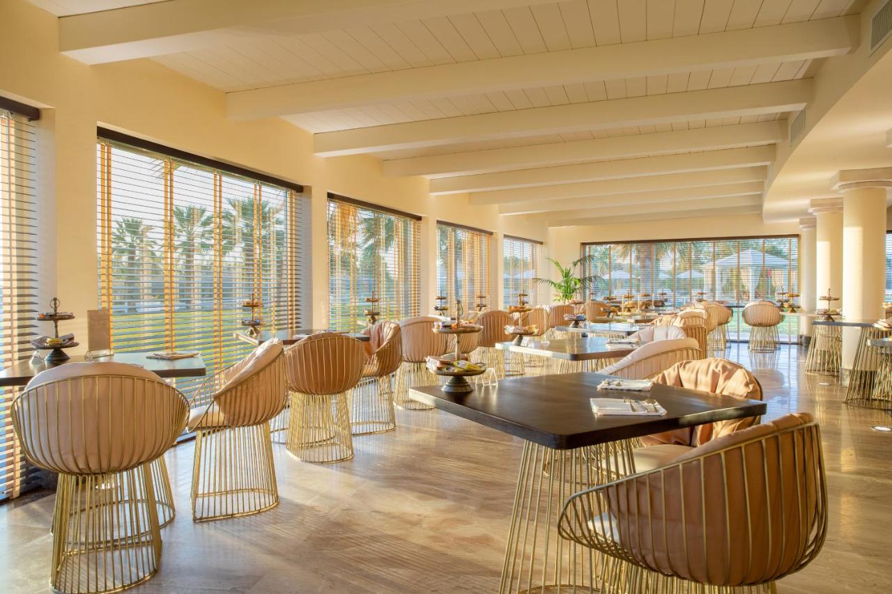 een restaurant met stoelen, tafels en ramen bij Spiagge San Pietro, a charming & relaxing resort in Castiadas