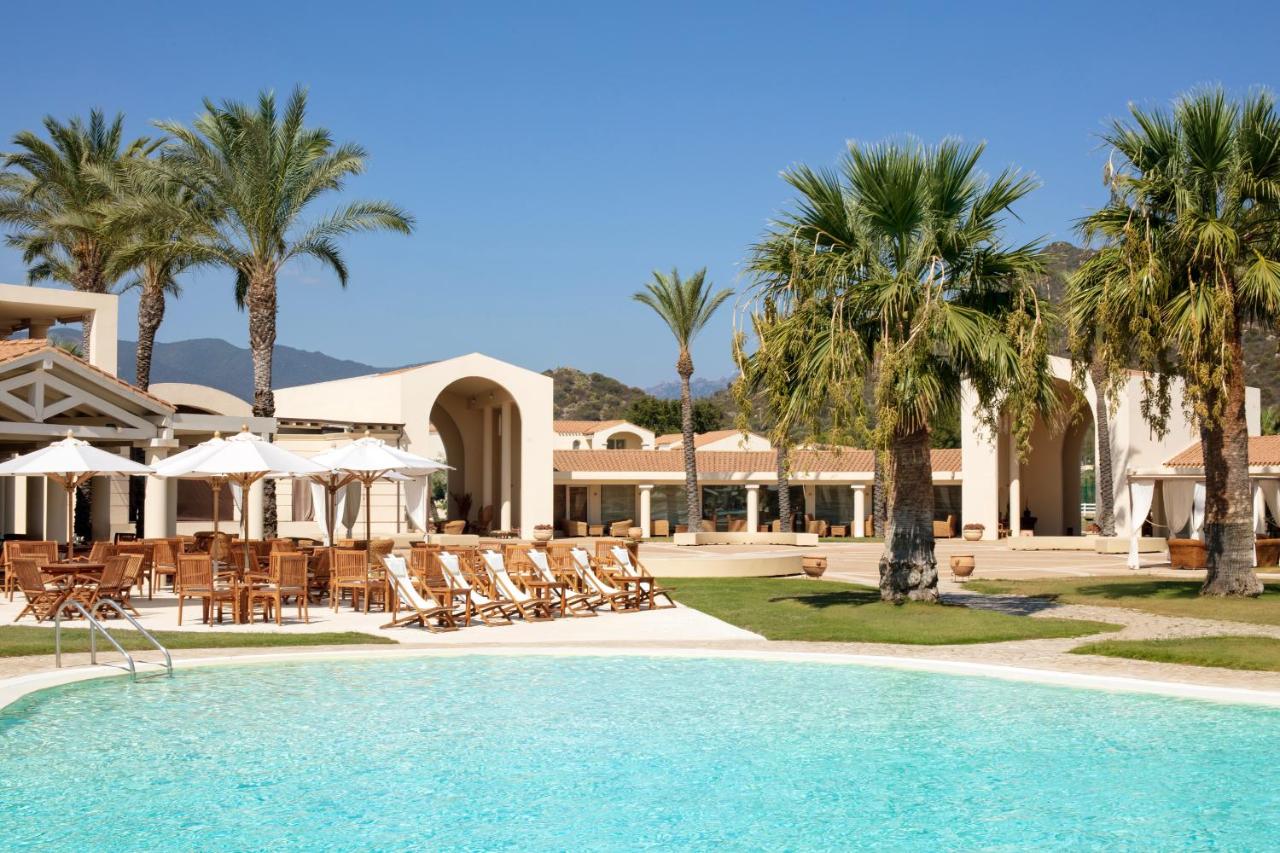 een resort met een zwembad, ligstoelen en palmbomen bij Spiagge San Pietro, a charming & relaxing resort in Castiadas