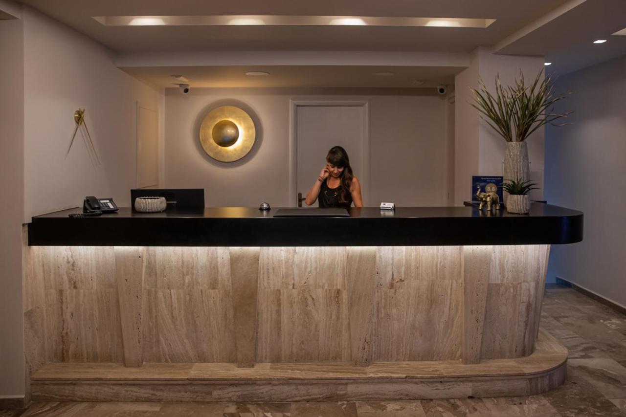 een vrouw die in een bar aan het bellen is met haar mobiele telefoon bij AGRELLI Hotel & Suites in Kardamaina +188 foto'