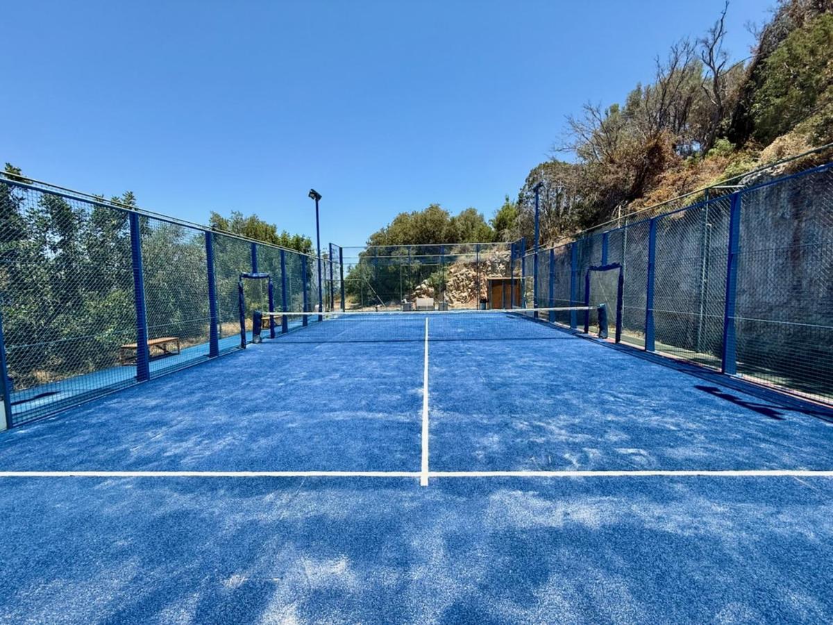 een lege tennisbaan met een hek eromheen bij Elpida Village in Istron