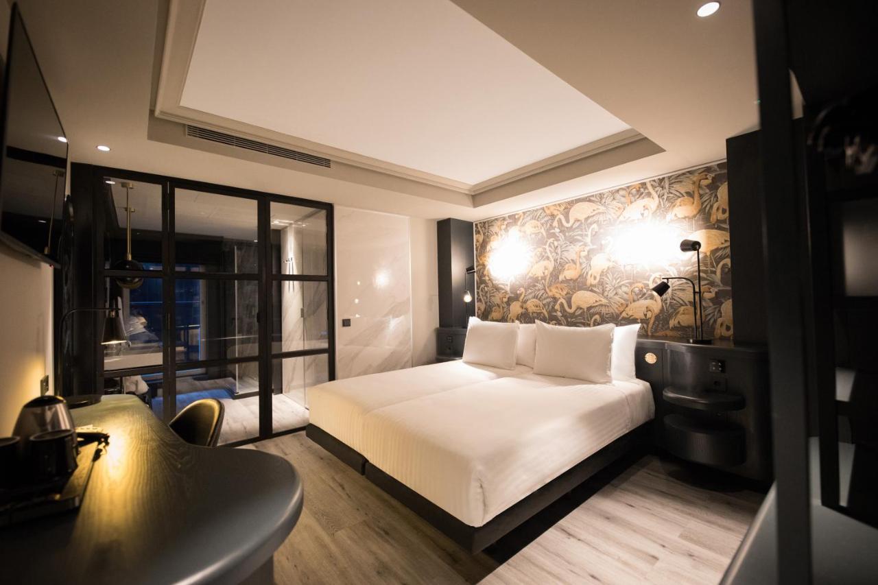een slaapkamer met een wit bed en een muur bij Silken Saaj Las Palmas in Las Palmas de Gran Canaria
