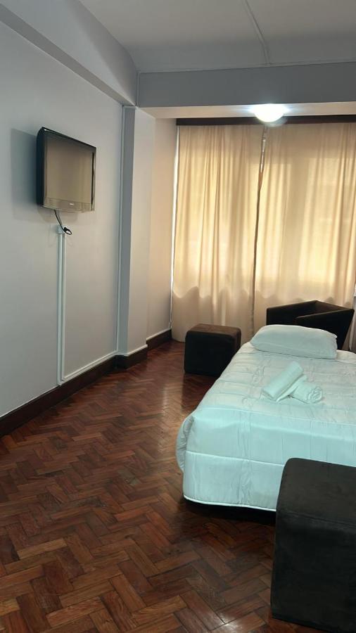 een slaapkamer met een bed en een flatscreen-tv bij Alojamento Central II in Funchal
