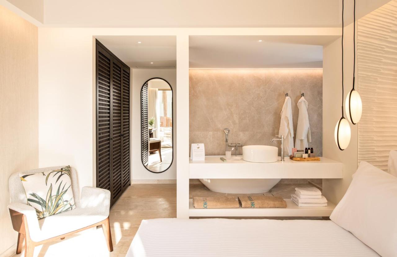 een badkamer met een wastafel en een spiegel bij Mitsis Selection Rinela in Kokkíni Khánion
