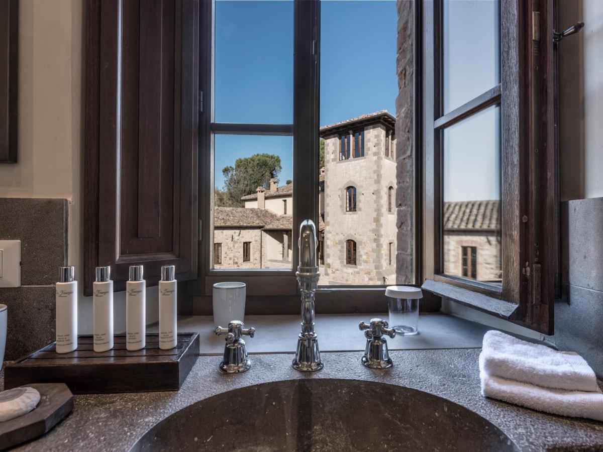 een wastafel in de badkamer met uitzicht op een kasteel bij Castel Monastero - The Leading Hotels of the World in Castel