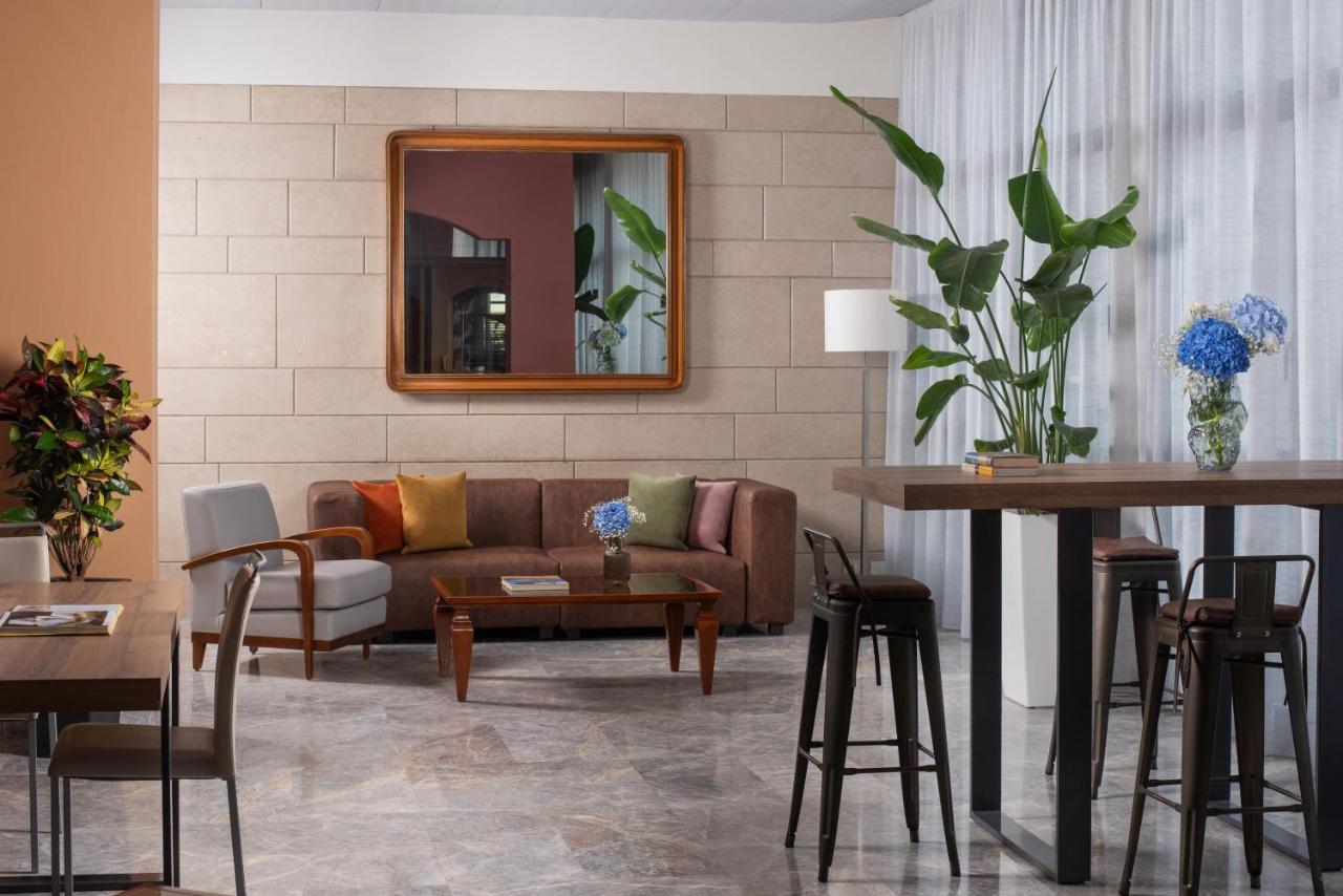 een woonkamer met een bank en een tafel bij NH Ancona in Ancona