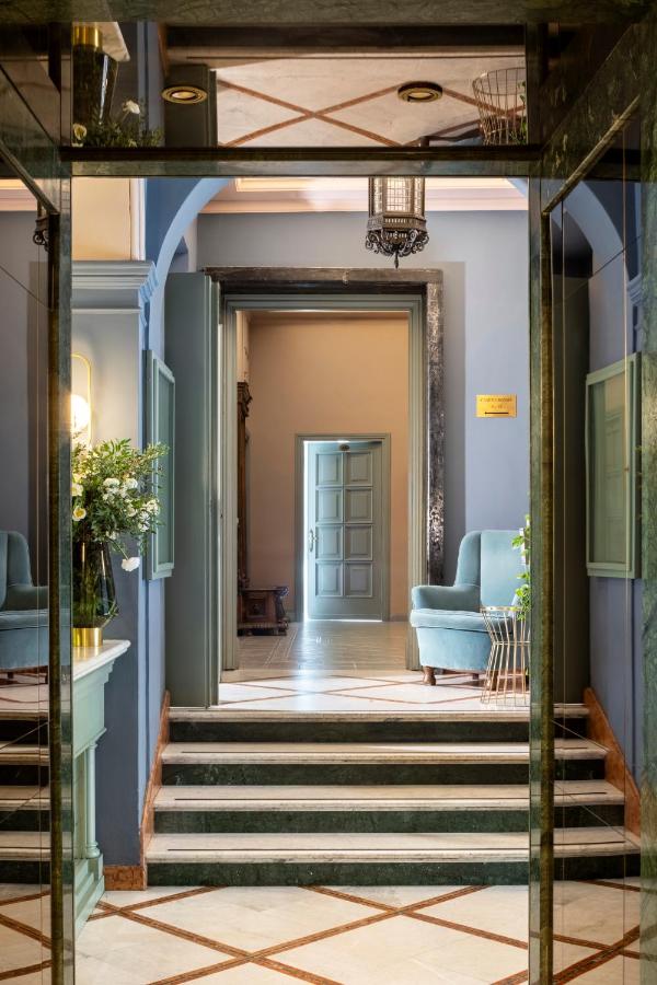 een gang met blauwe muren en een trap met een blauwe bank bij Hotel Marisa in Rome
