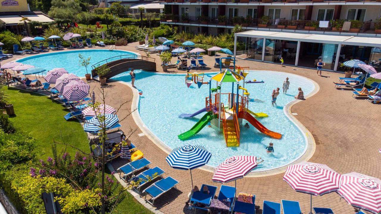 een zwembad met een glijbaan in een resort bij Hotel Bella Italia in Peschiera del Garda