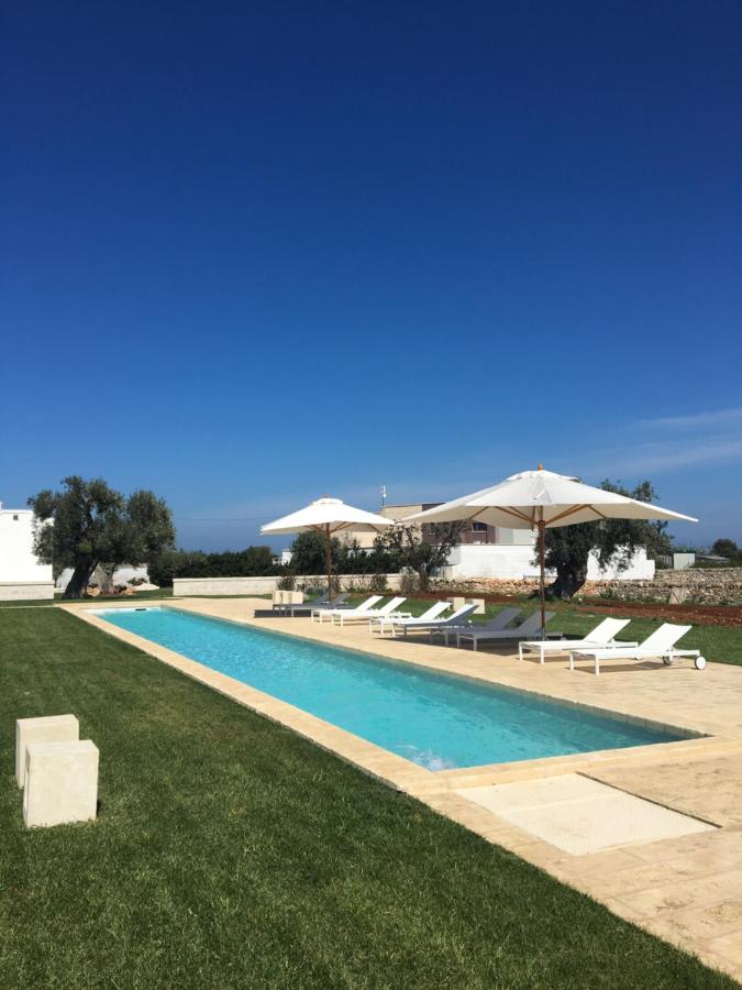 een zwembad met ligstoelen en parasols bij Masseria San Giovanni - Epoca Collection in Fasano