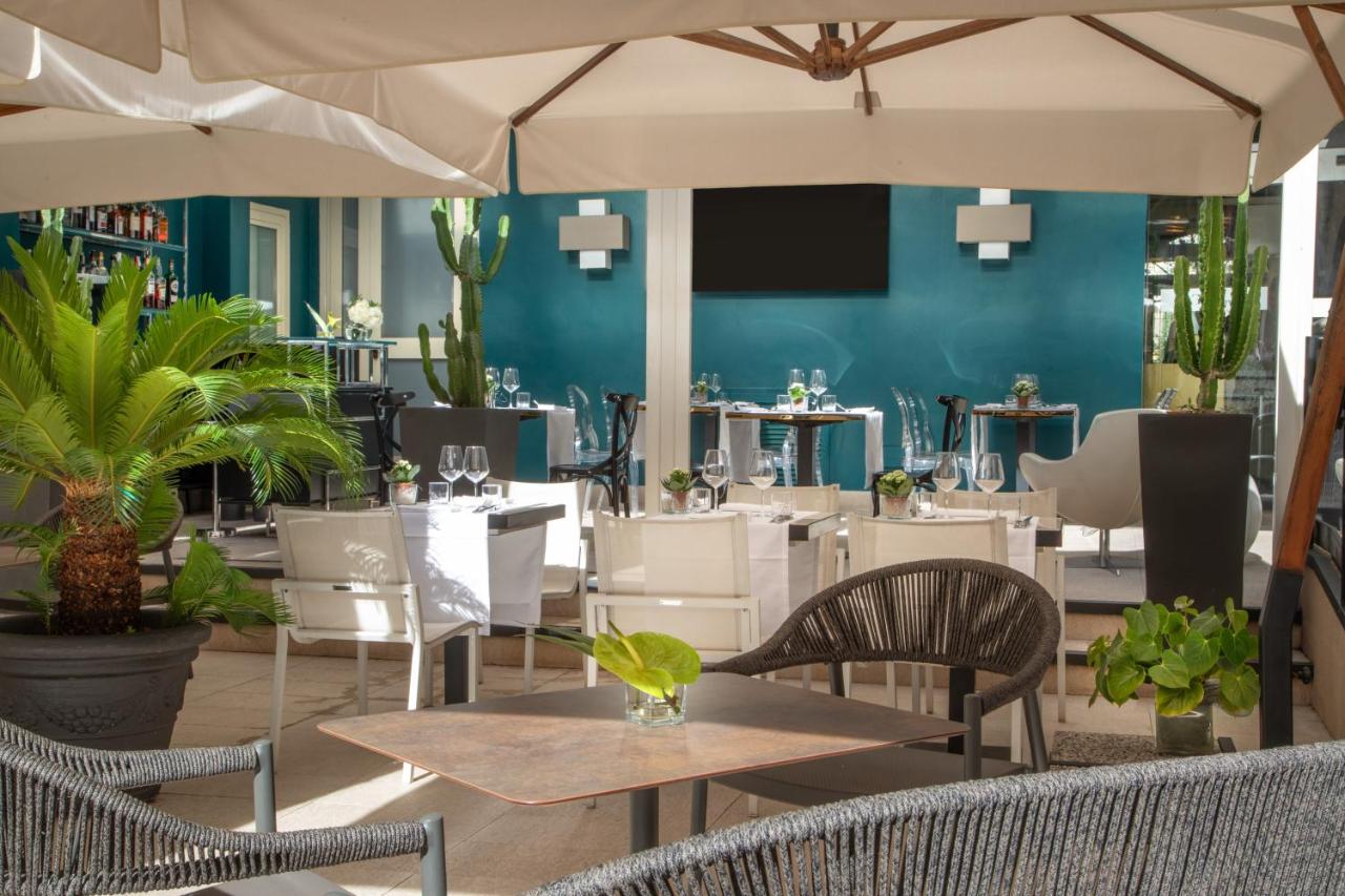 een restaurant met tafels en stoelen en een blauwe muur bij The Guardian in Rome