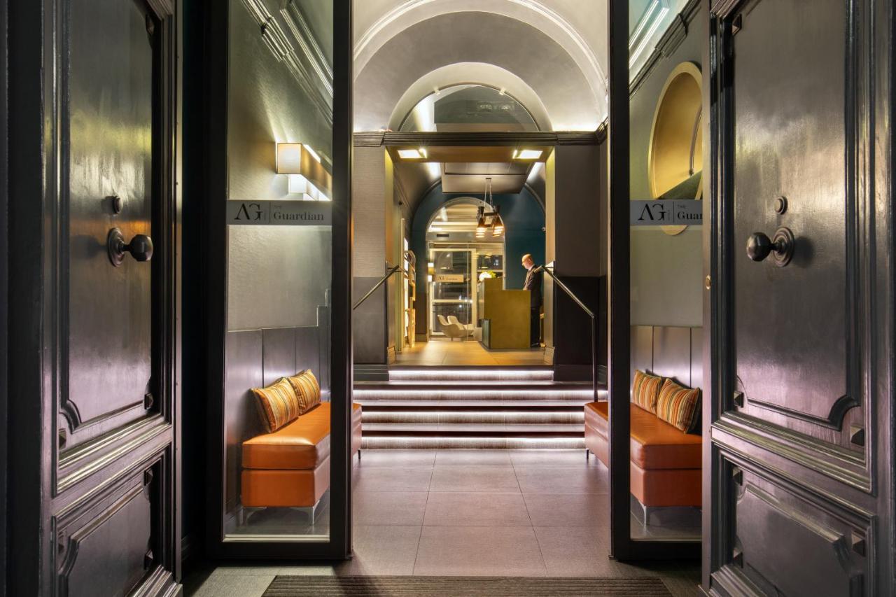 een gang met oranje stoelen en een trap in een gebouw bij The Guardian in Rome