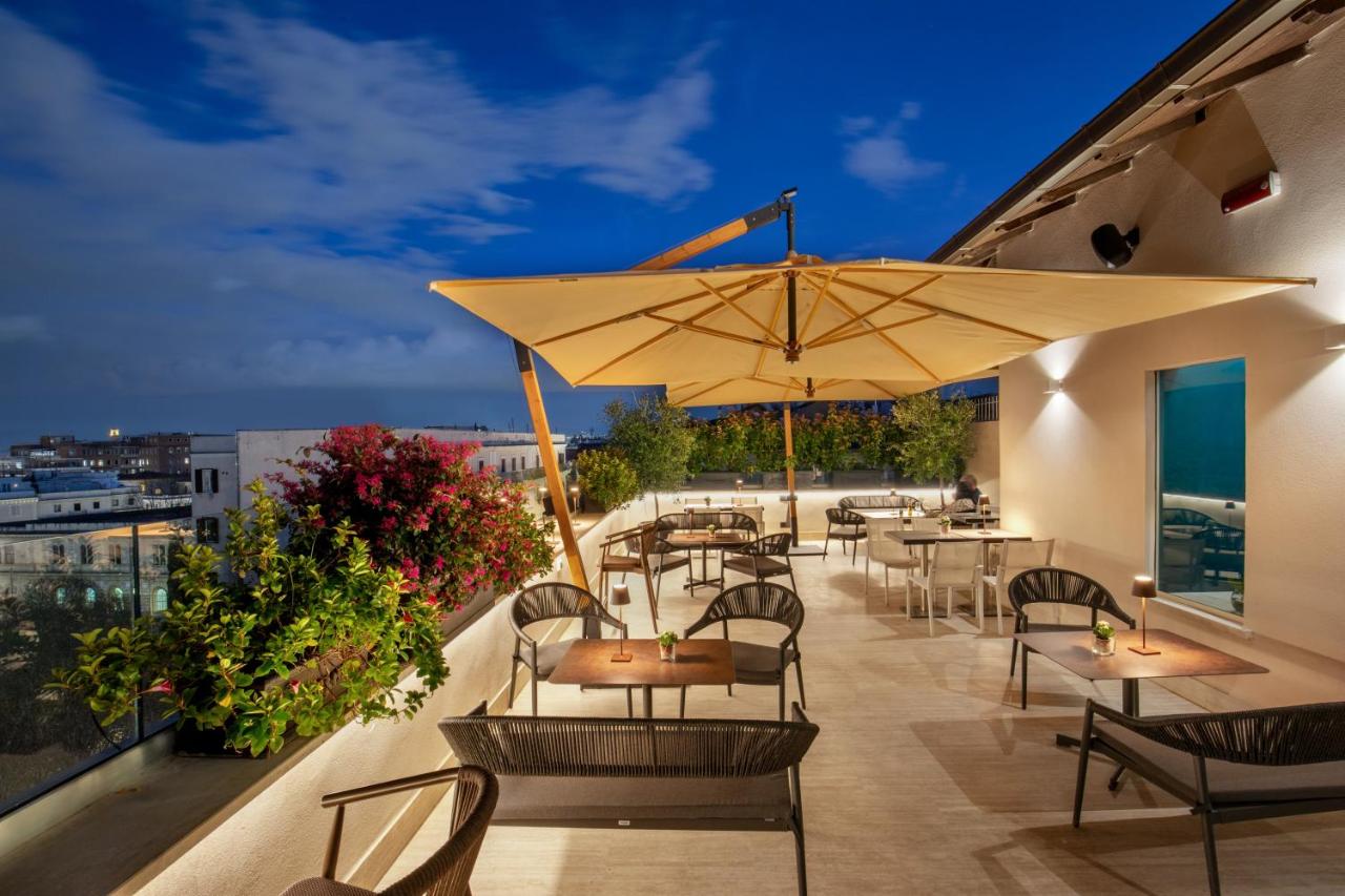 een terras met tafels en parasols op een balkon bij The Guardian in Rome