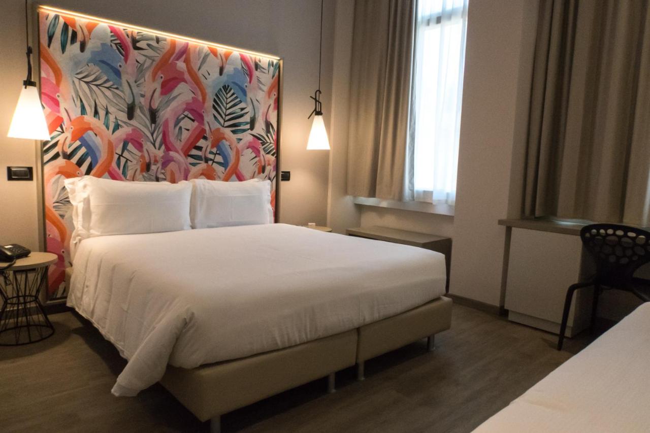 een hotelkamer met een groot bed met een kleurrijk hoofdbord bij Hotel San Giovanni Roma in Rome