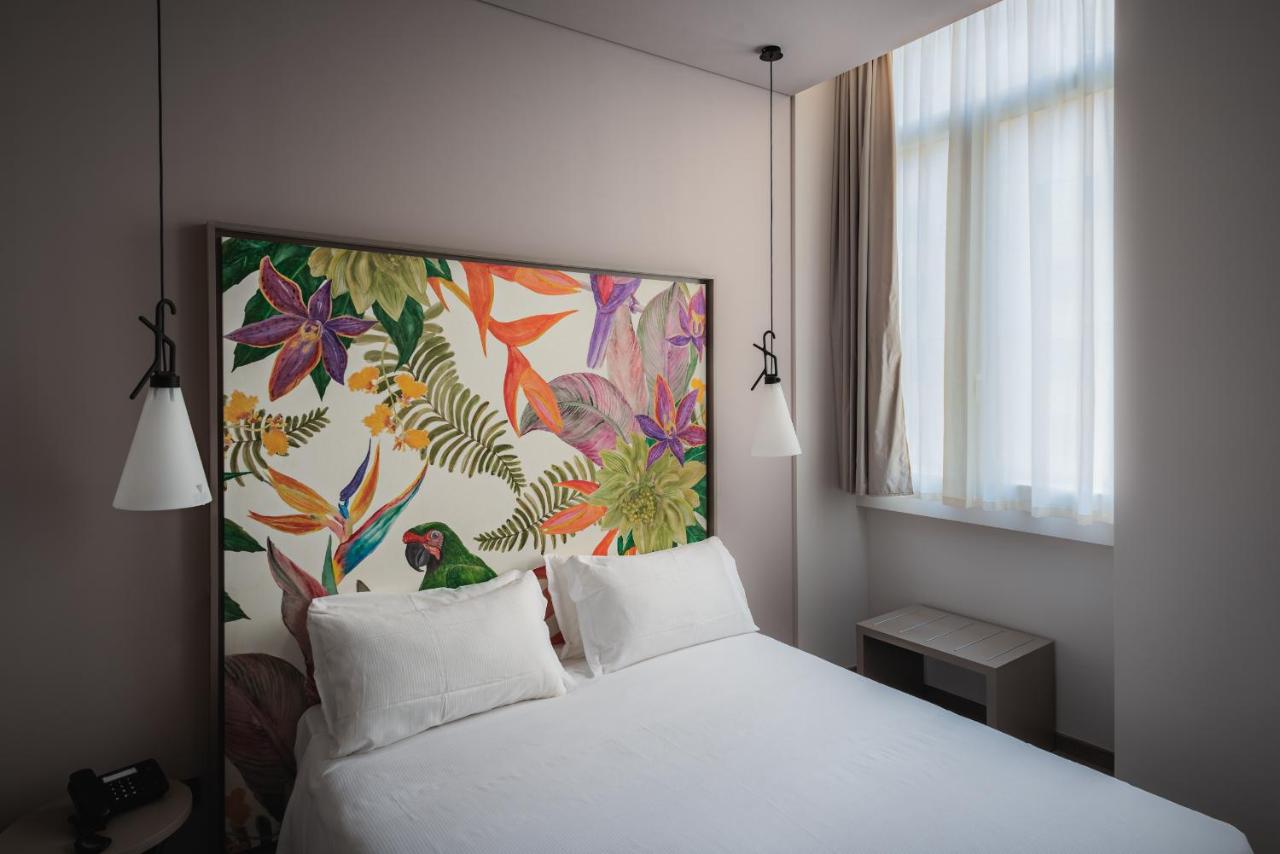 een slaapkamer met een wit bed en een schilderij aan de muur bij Hotel San Giovanni Roma in Rome