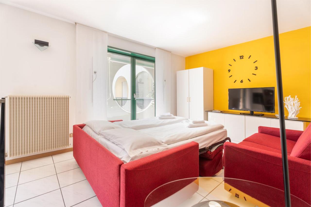een slaapkamer met een bed en twee rode stoelen bij Brione paradise in Riva del Garda