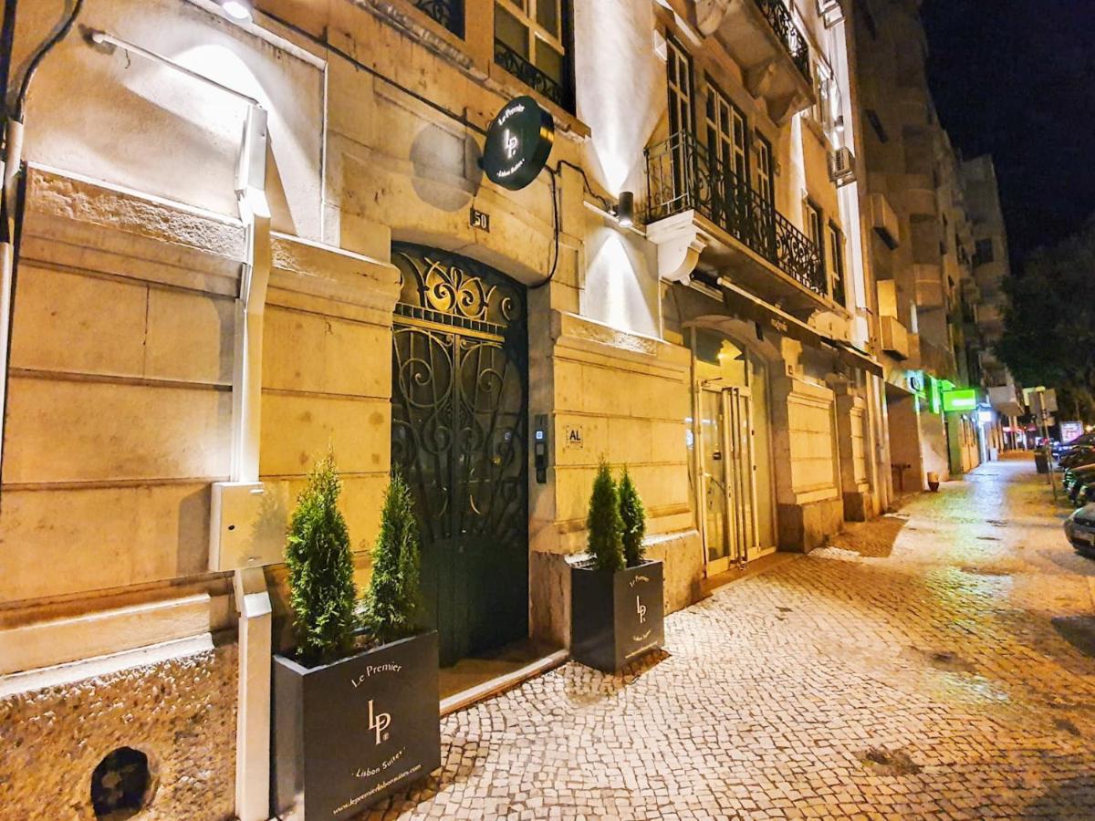 een gebouw met een deur en twee potplanten aan een straat bij Le Premier Lisbon Suites in Lissabon