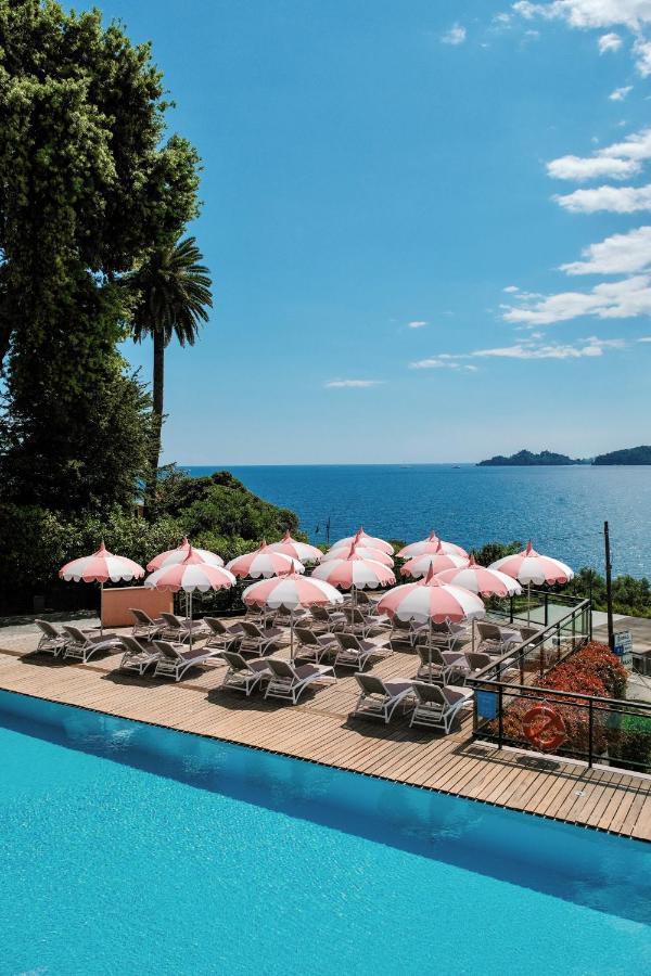 een groep roze parasols en stoelen naast een zwembad bij Grand Hotel Bristol Spa Resort, by R Collection Hotels in Rapal