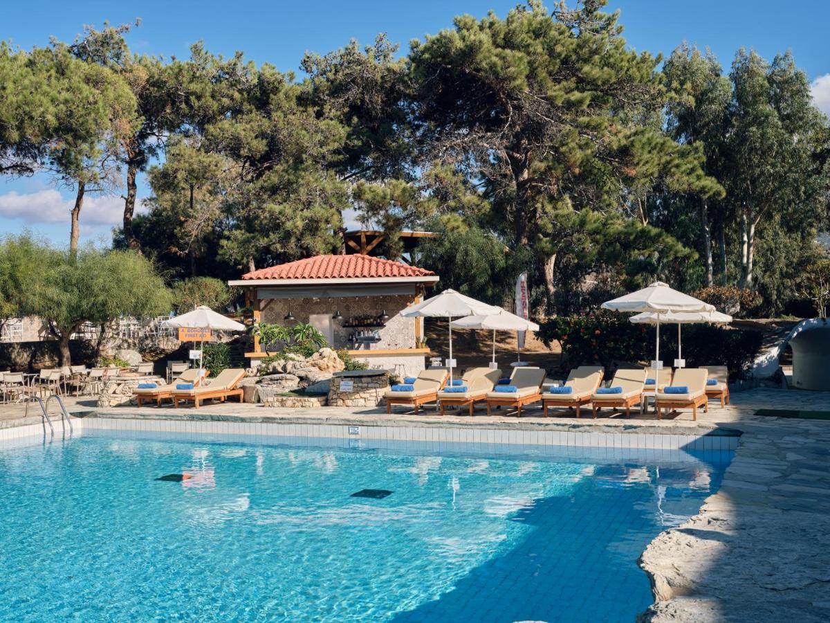 een zwembad met ligstoelen en parasols bij Sitia Beach City Resort & Spa in Sitia