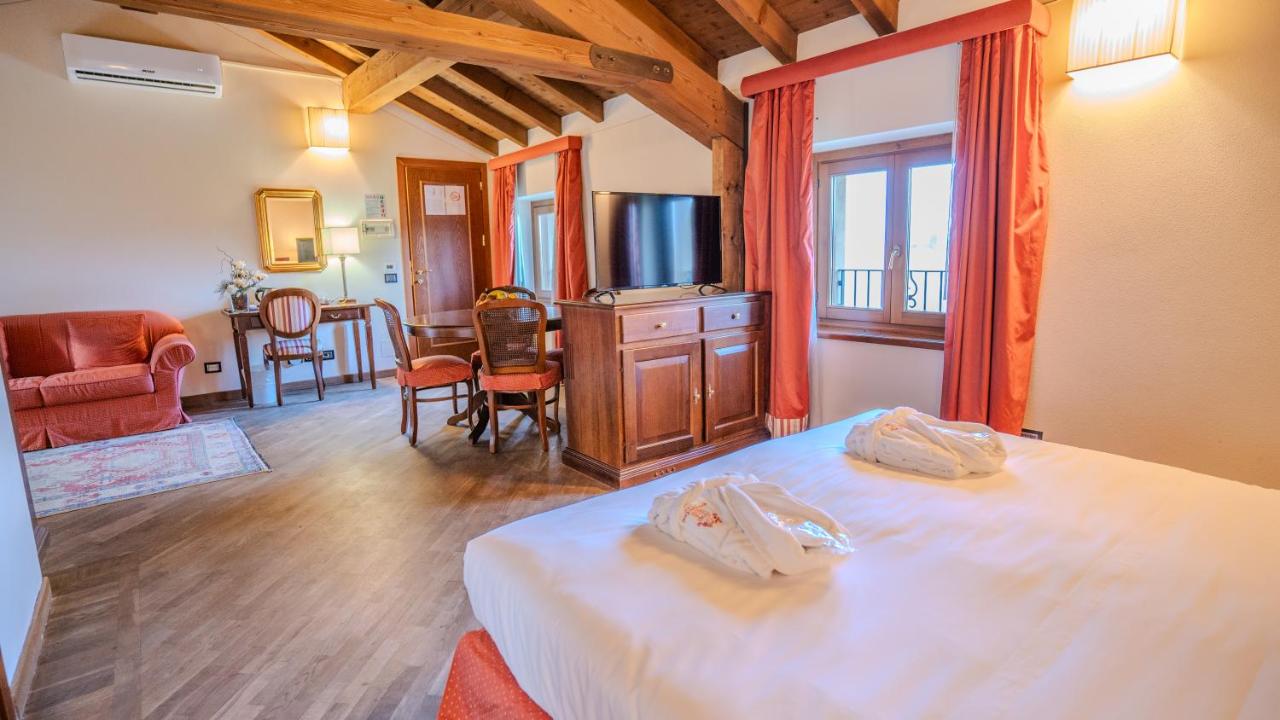 een slaapkamer met een bed en een eetkamer bij Relais Corte Cavalli in Ponti Sul Mincio