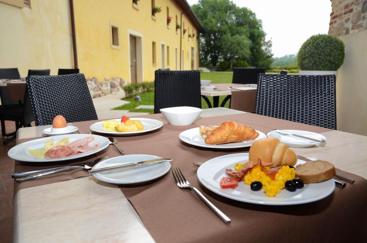 een tafel met borden ontbijt erop bij Relais Corte Cavalli in Ponti Sul Mincio