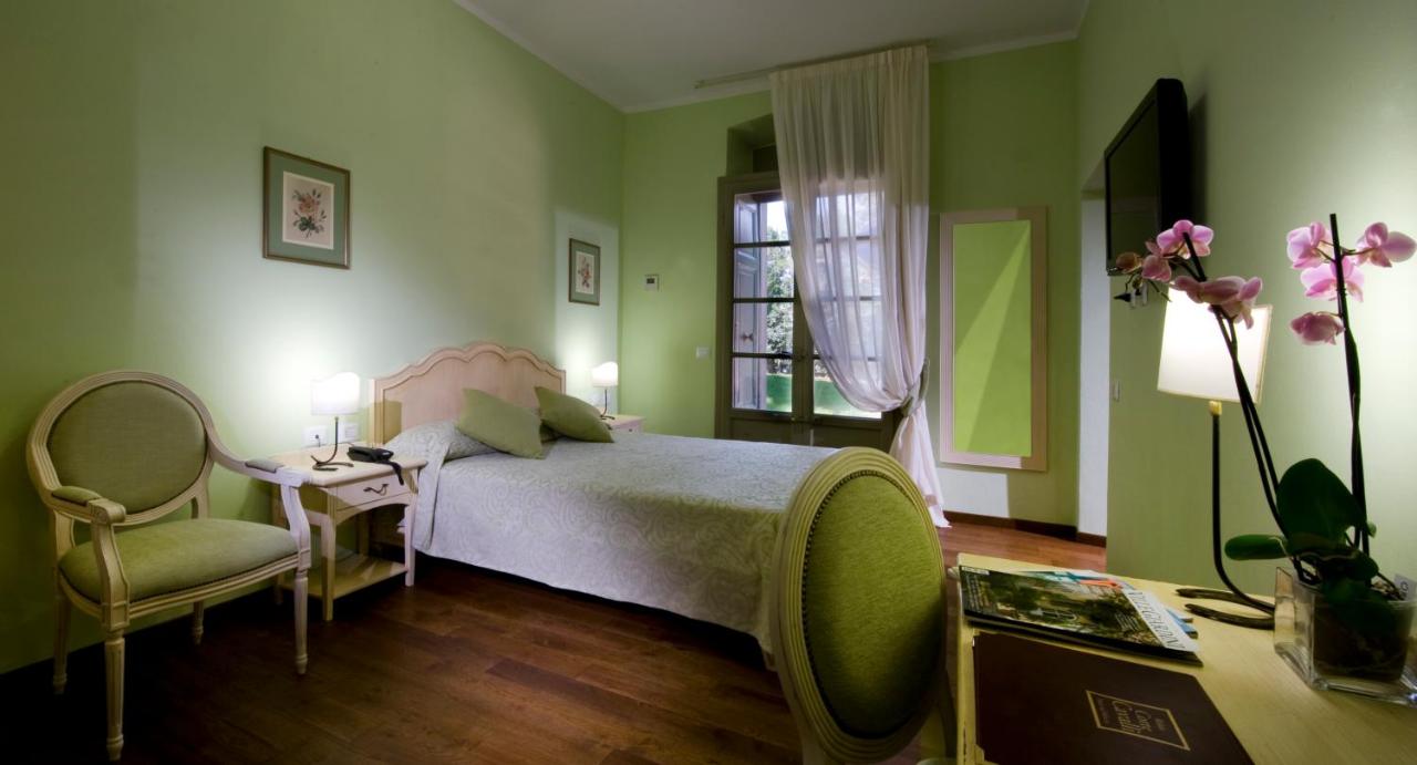 een slaapkamer met een bed, een tafel en een stoel bij Relais Corte Cavalli in Ponti Sul Mincio