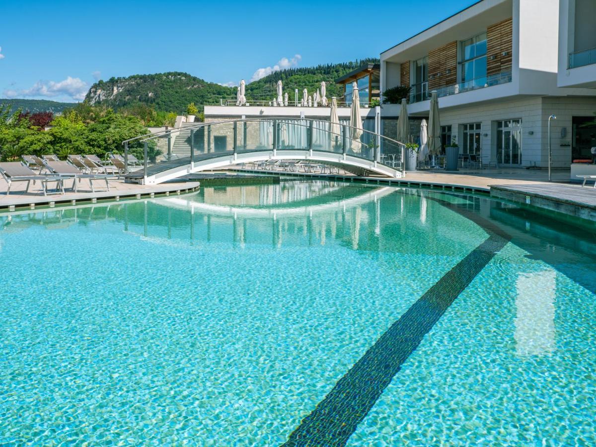 een zwembad met een brug in een gebouw bij Parc Hotel Germano Suites & Apartments in Bardolino