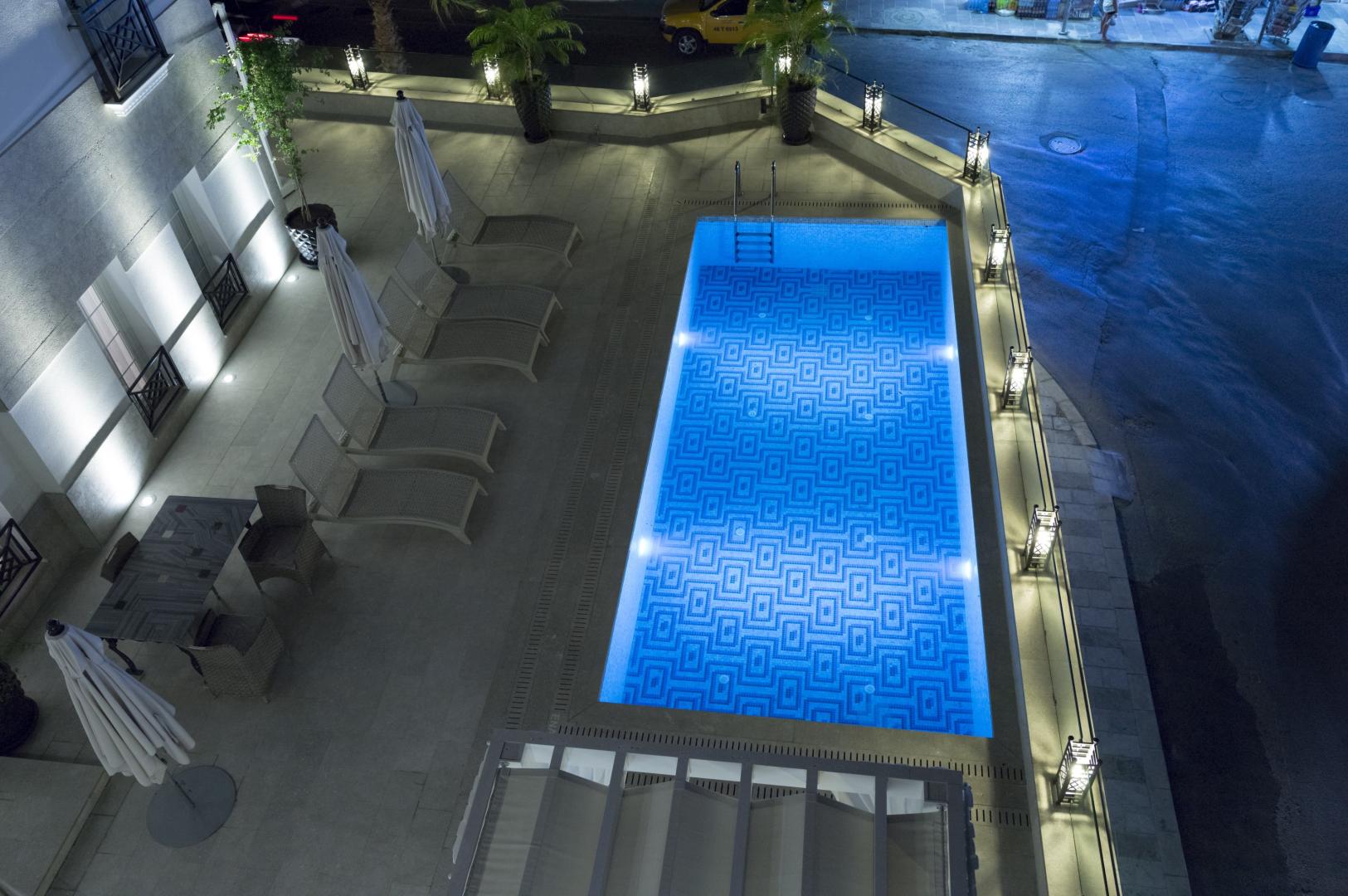 Buitenzwembad met ligbedden — Ena Boutique Hotel