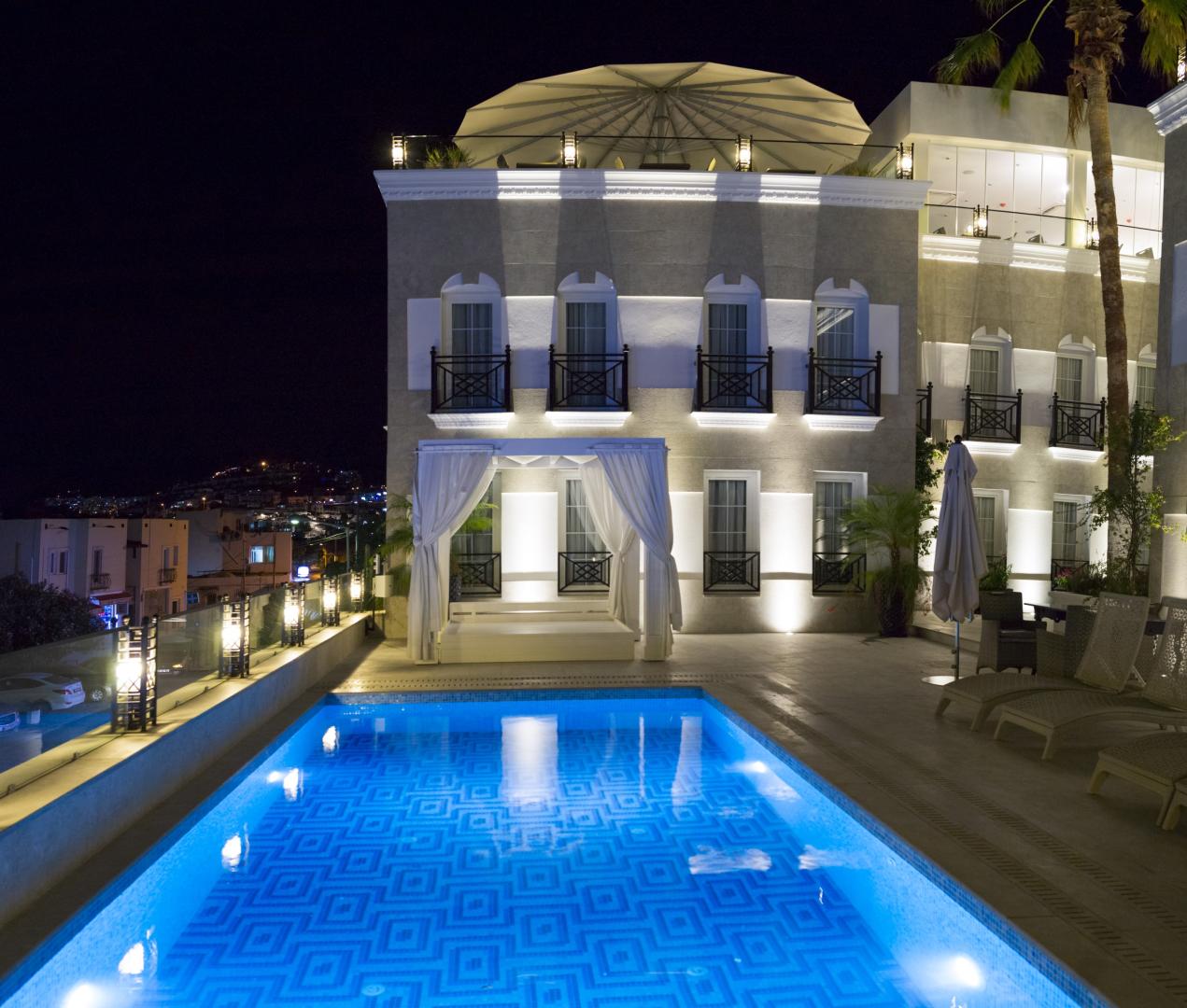 Zwembad omringd door palmbomen — Ena Boutique Hotel