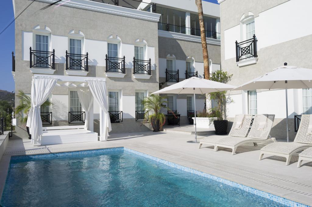 Buitenzwembad met ligbedden — Ena Boutique Hotel