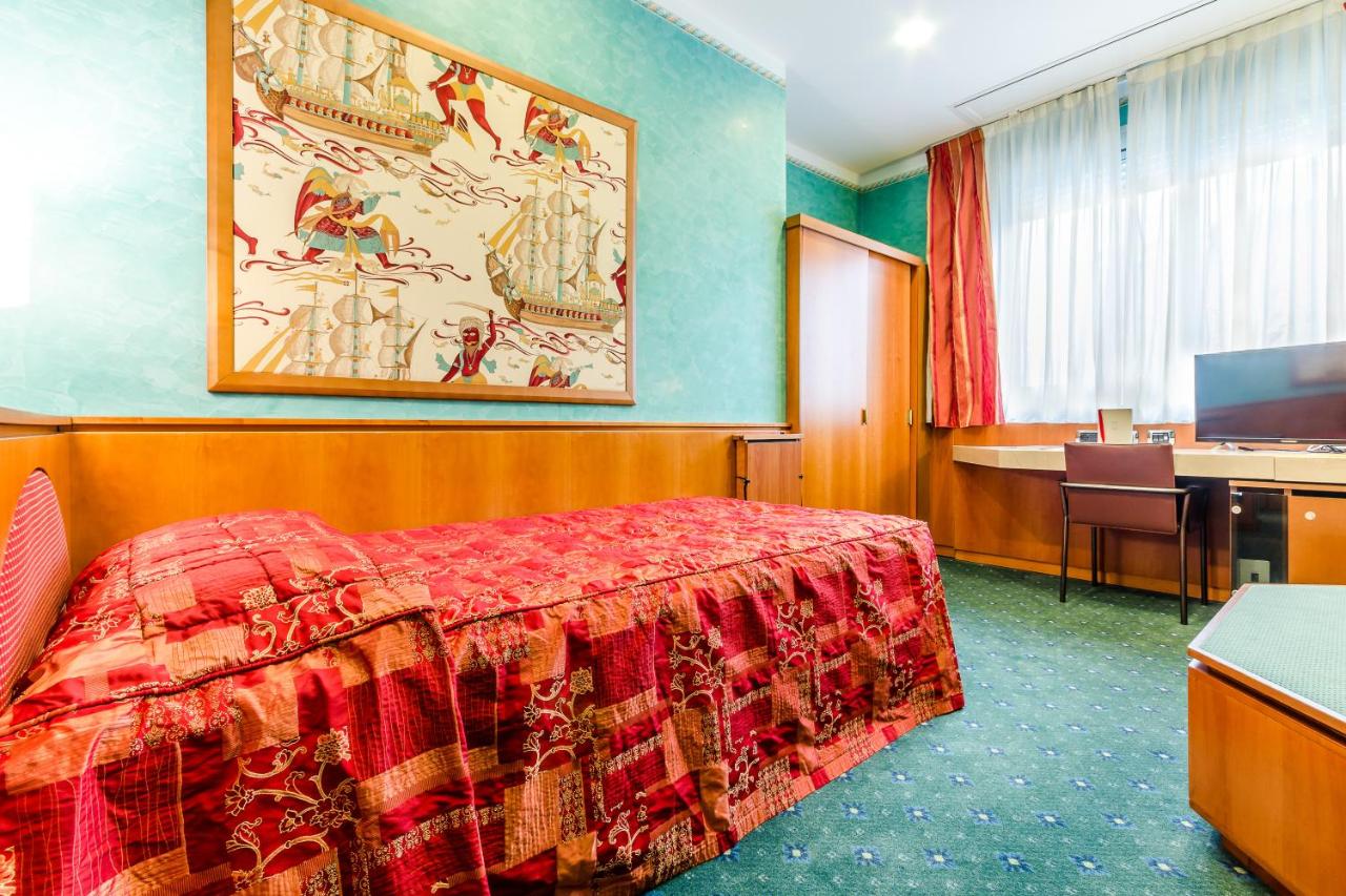 een hotelkamer met een bed en een bureau bij Brunelleschi Hotel in Milaan