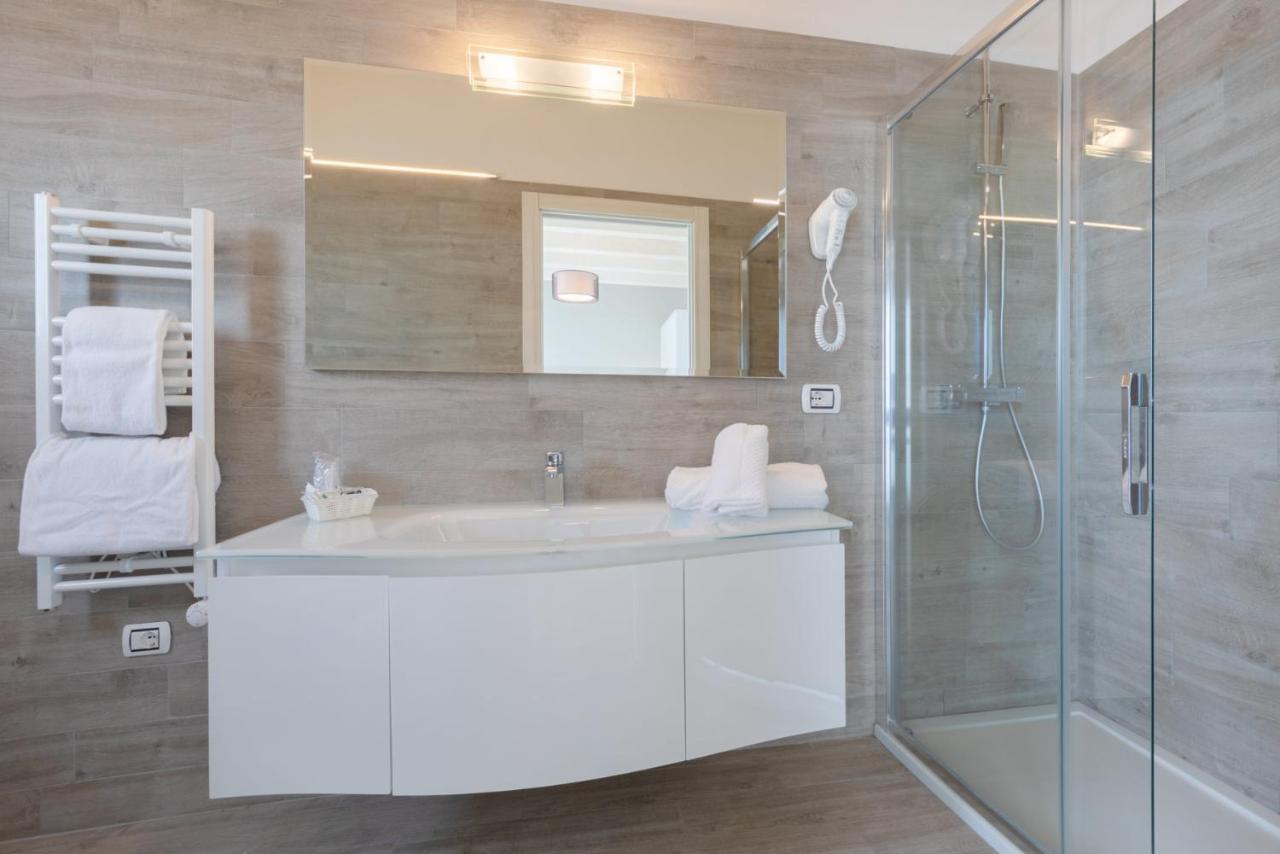 een badkamer met een witte wastafel en een douche bij Eraclea Palace Hotel 4 stelle S in Eraclea Mare