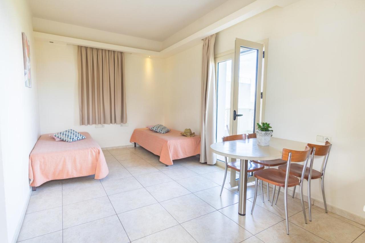 een kamer met een tafel, een bed en een raam bij Pela Sofia in Stalida +103 foto's
