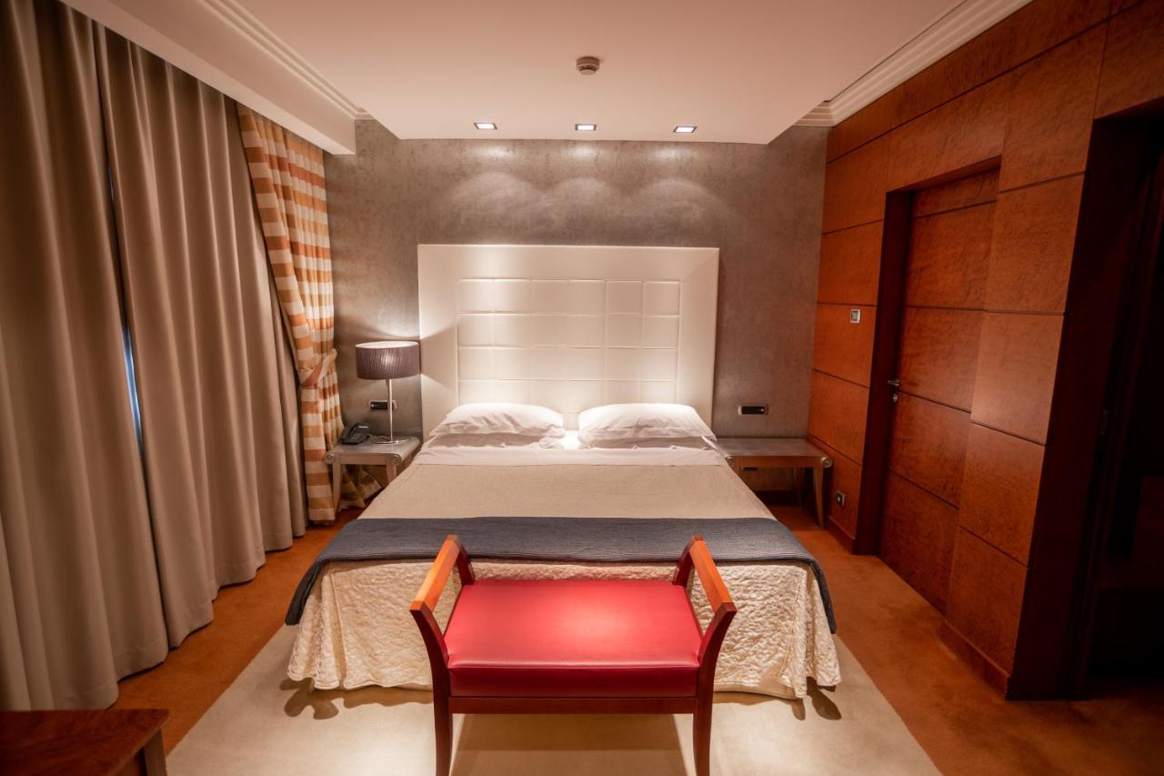 een slaapkamer met een bed en een rode stoel bij Papillo Hotels & Resorts Roma in Rome