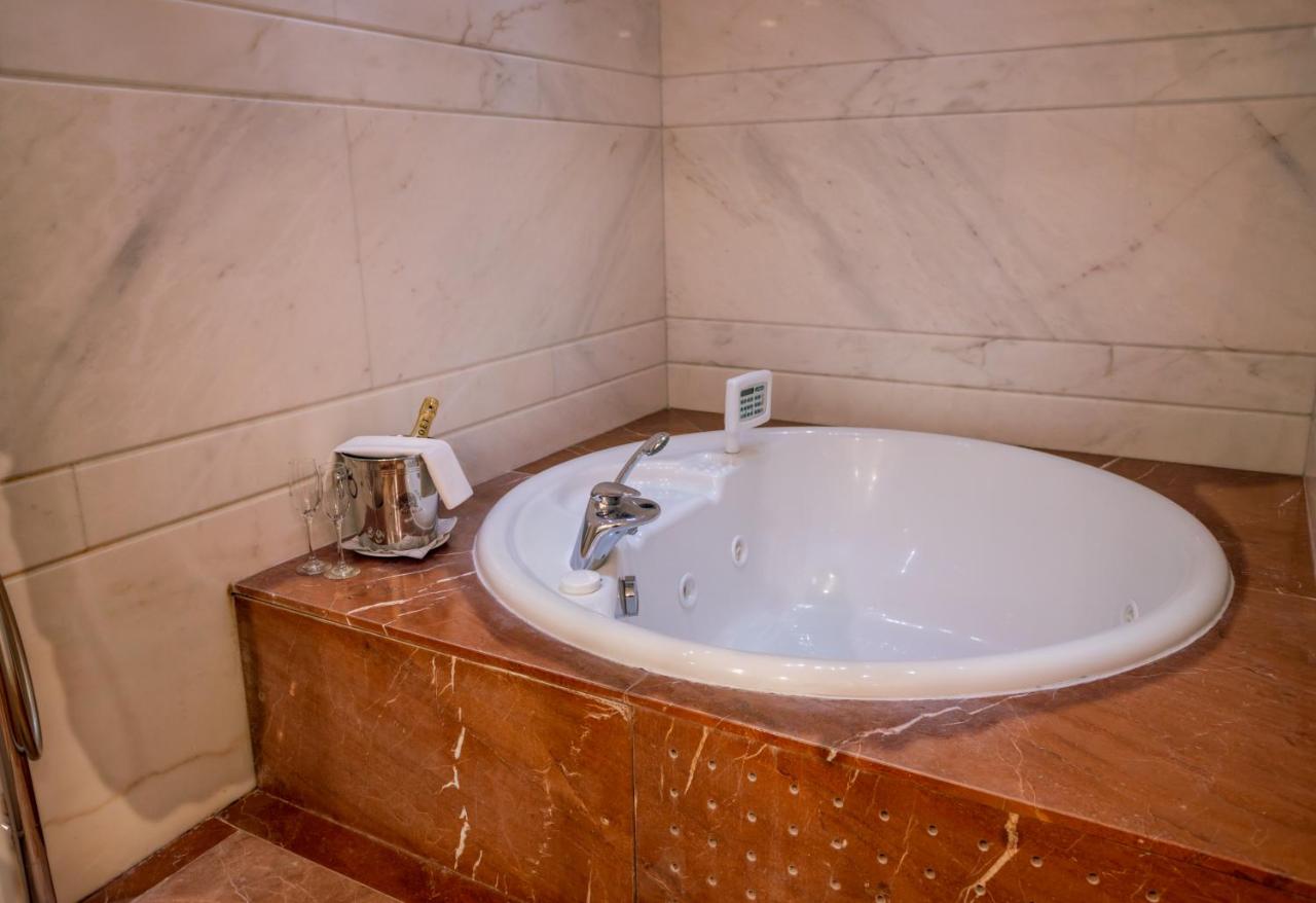 een badkamer met een witte wastafel op een houten aanrechtblad bij Papillo Hotels & Resorts Roma in Rome