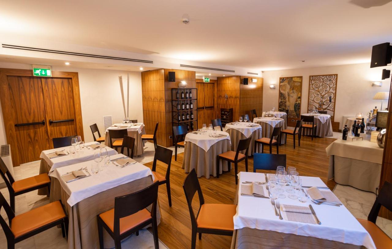 een eetkamer met tafels en stoelen met witte tafelkleden bij Papillo Hotels & Resorts Roma in Rome