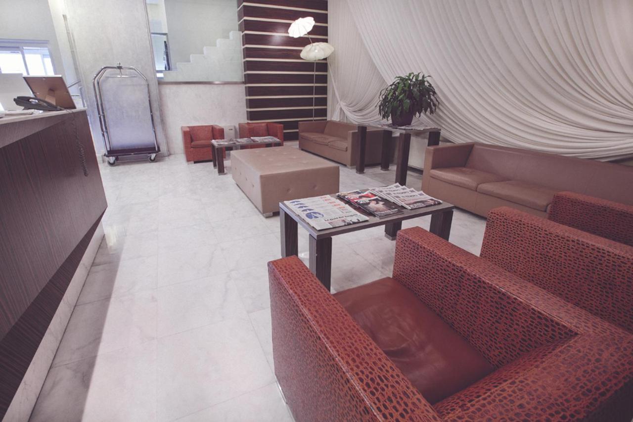 een woonkamer met banken, een tafel en stoelen bij Papillo Hotels & Resorts Roma in Rome