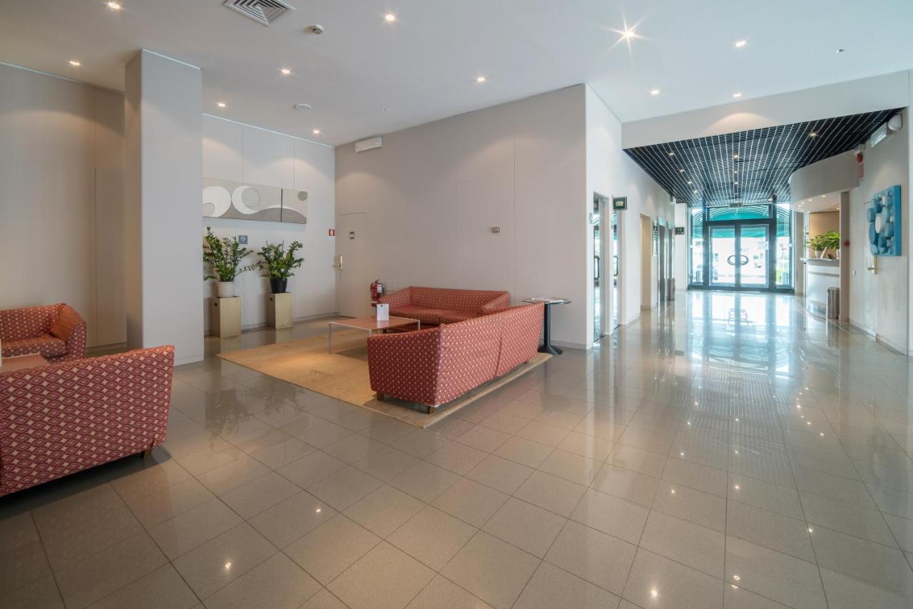 een lobby met banken en een tafel in een gebouw bij Idea Hotel Piacenza in Piacenza