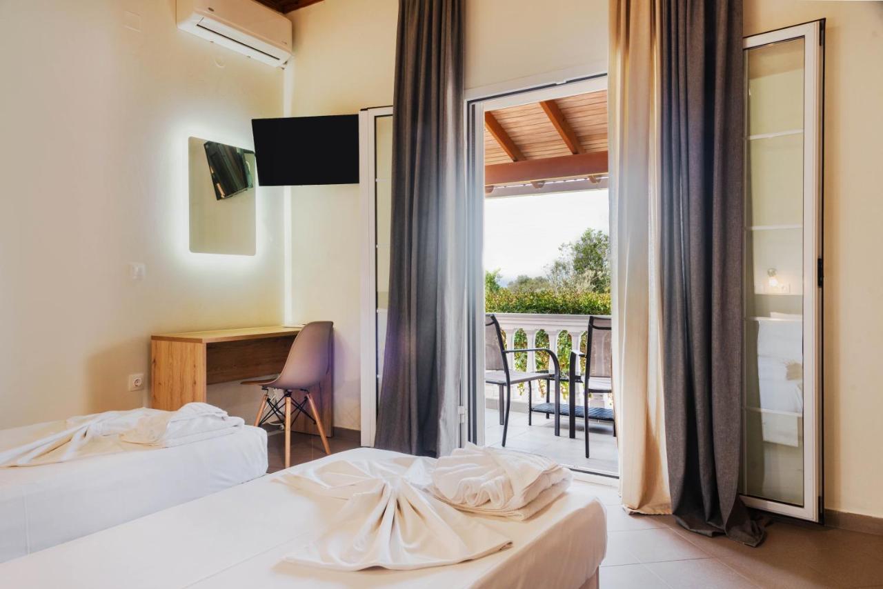 een slaapkamer met twee bedden, een bureau en een balkon bij Riposo Studios & Apartments in Kavos +94 foto's