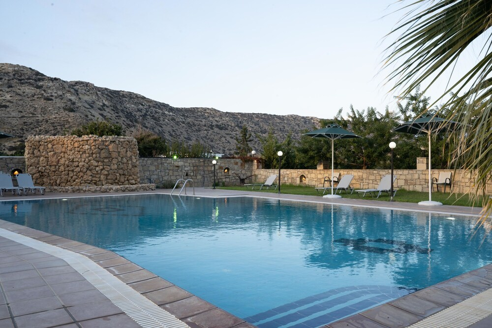 Zwembad omringd door palmbomen — Dimitris Resort Hotel