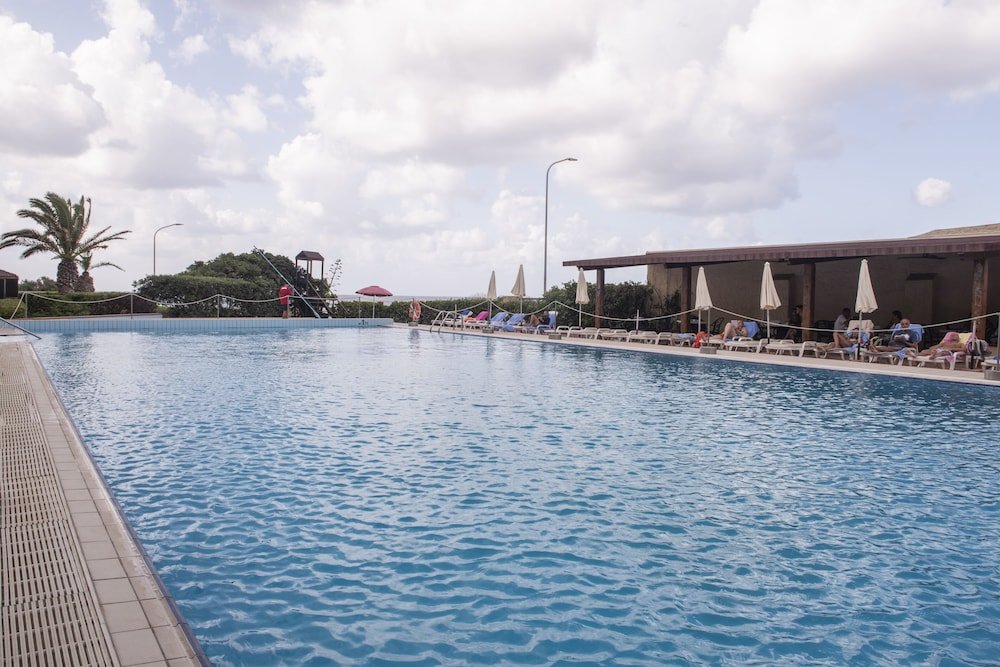 Zwembad omringd door palmbomen — Hotel Calabona