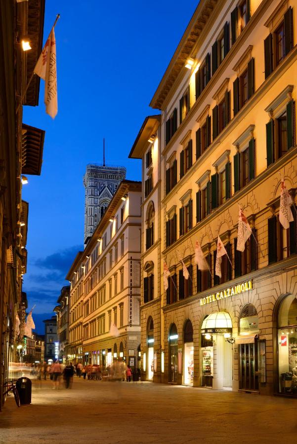 een stadsstraat 's nachts met gebouwen bij FH55 Hotel Calzaiuoli in Florence