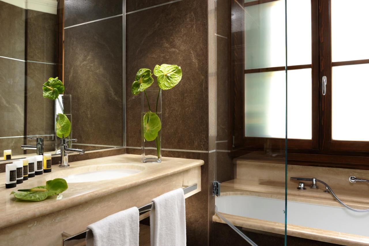 een badkamer met een wastafel en een spiegel bij FH55 Hotel Calzaiuoli in Florence +71 foto's