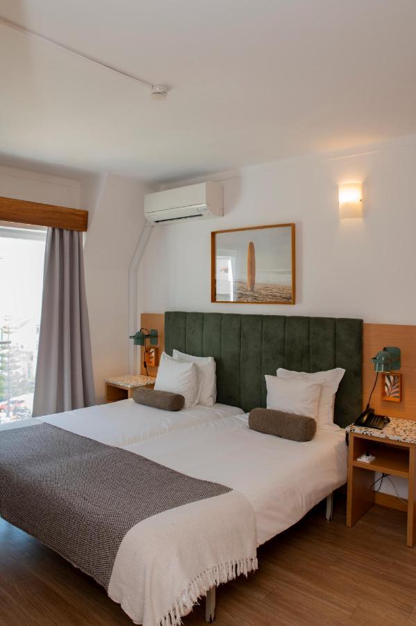 een slaapkamer met een groot bed met een groen hoofdeinde bij WOT Ericeira in Ericeira