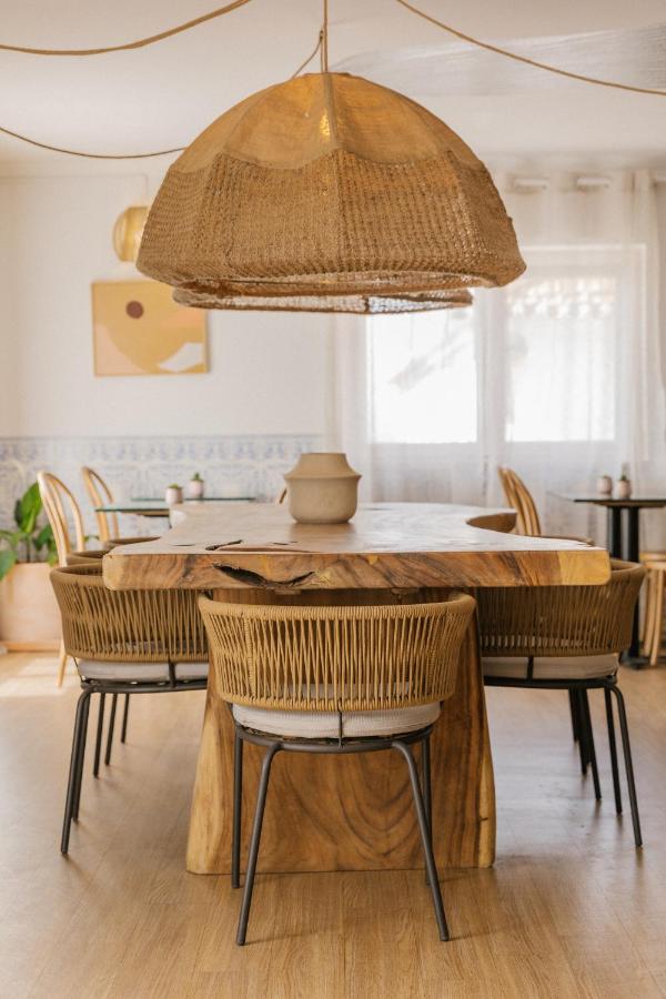 een eetkamer met een houten tafel en stoelen bij WOT Ericeira in Ericeira