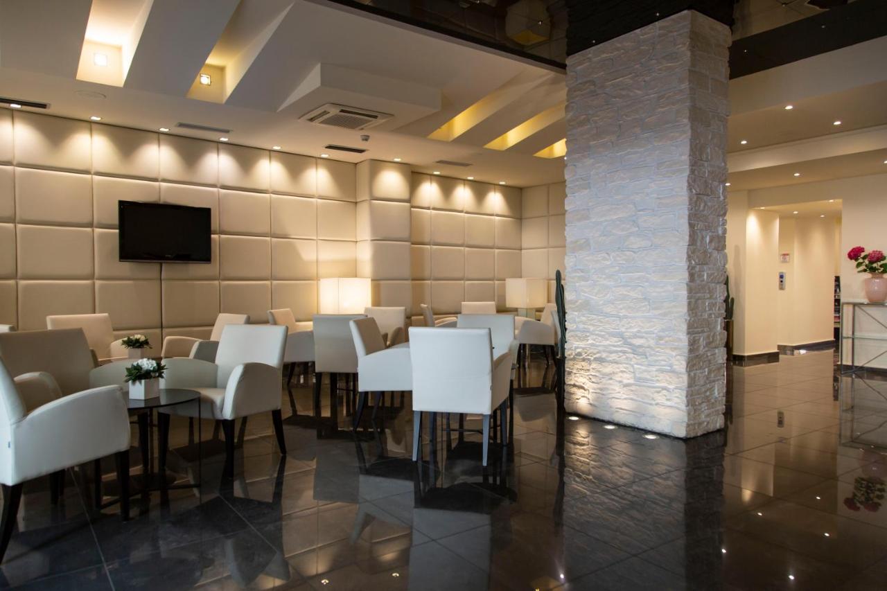 een eetkamer met witte tafels en stoelen en een tv bij Hotel Antico Borgo in Riva del Garda
