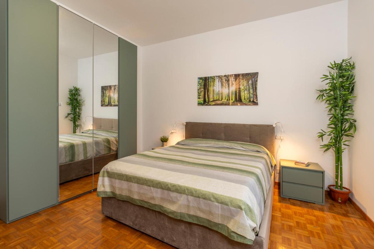 een slaapkamer met een groot bed en een spiegel bij garda garden apartment in Roe
