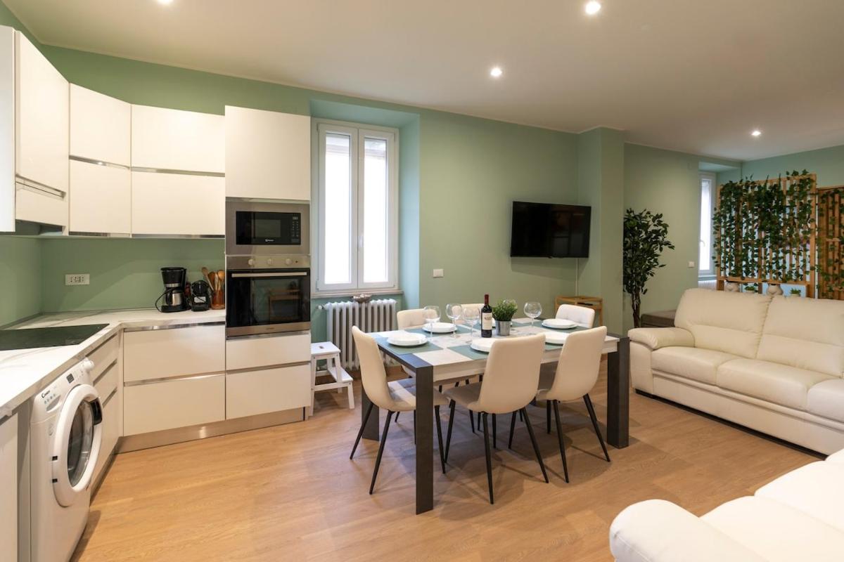 een keuken en woonkamer met een tafel en stoelen bij garda garden apartment in Roe