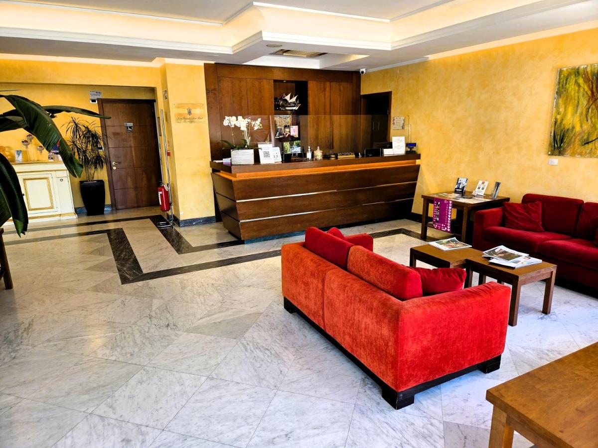 een lobby met een rode bank en een toonbank bij Santa Caterina Park Hotel in Sarzana