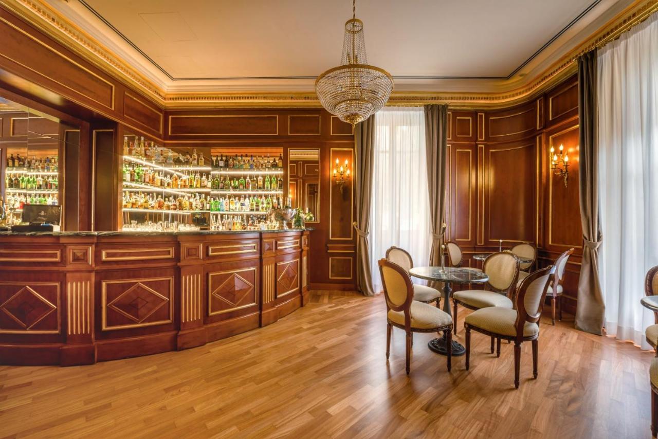 een bar met houten wanden en een tafel en stoelen bij Grand Hotel Wagner in Palermo